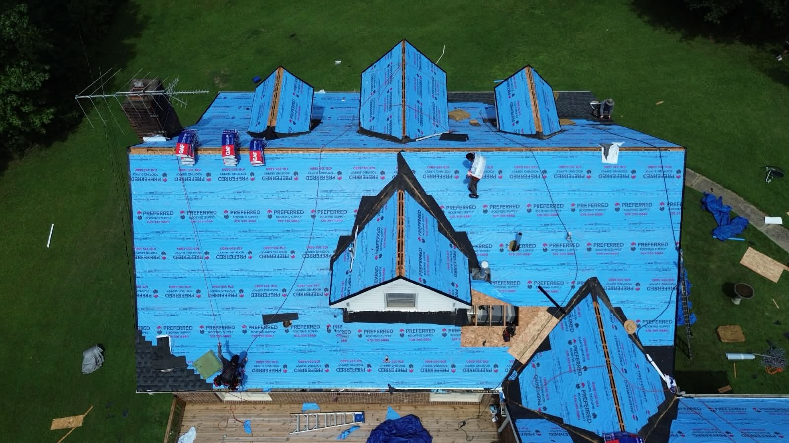 Installers laying architectural shingles over GAF underlayment